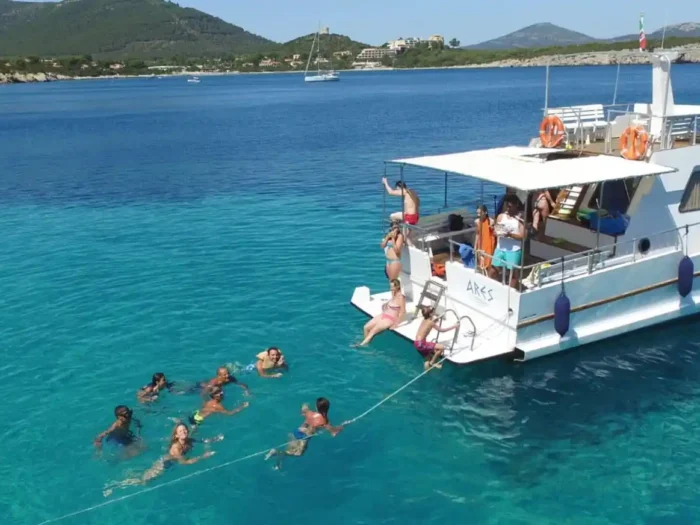 Gruppo di persone che fa il bagno durante un'escursione in barca ad Alghero con Ares Turismo.
